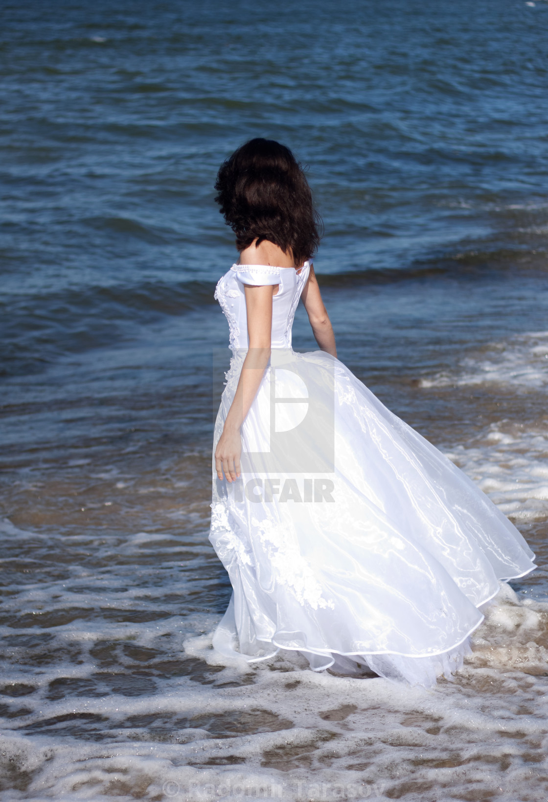 Брюнетка на море со спины в платье